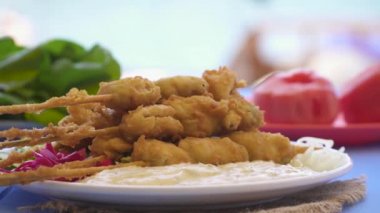 Kızarmış midye sopa ve ahşap mavi masa, Foça Izmir Türkiye'de deniz kenarında sosu ile