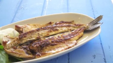 Soğan ve roket ile ızgara balık plaka üzerinde çekim pan kadar yakın bırakır. İyi yemek. 