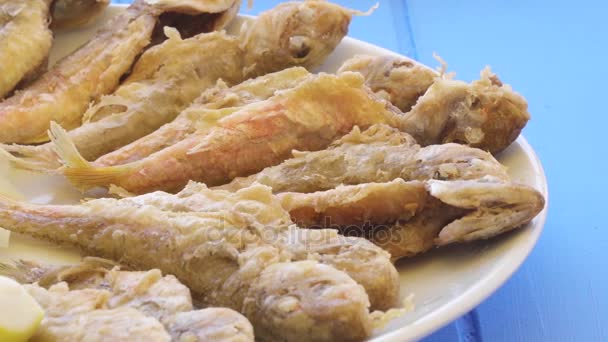 Piatto di pesce fritto triglia rossa con rucola e limone, vista da vicino . — Video Stock