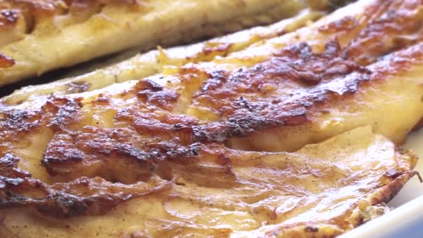 Poisson grillé avec des feuilles d'oignon et de fusée sur la plaque close up pan shot. Bravo cuisinier . — Video
