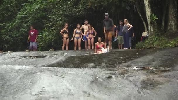 Paraty, Ρίο ντε Τζανέιρο - Βραζιλία - Αυγούστου 2017: Άνθρωποι που απολαμβάνουν σε έναν καταρράκτη. Συρόμενη βράχια και το νερό. — Αρχείο Βίντεο