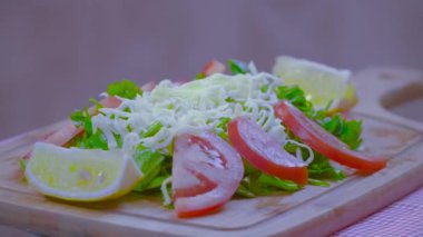 Lezzetli rendelenmiş Parmesan peyniri salatası malzemeler doğranmış roka veya roket, domates, limon ve atış dönen bambu kesme tahtası üzerinde hizmet veren maydanoz ile.