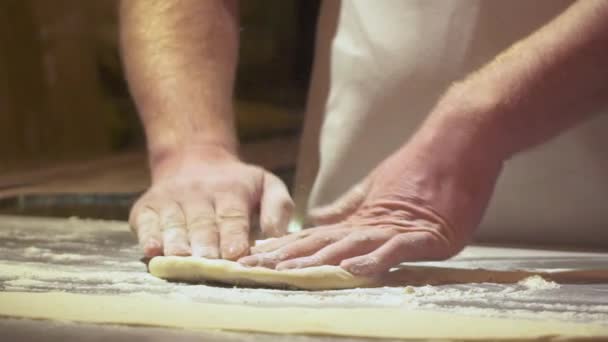 Vypečenou pizzu nebo pide Close mužské ruce v kuchyni. Tvarování těsta je prekurzorem k tomu širokou škálu potravin, zejména chléb, sušenky, koláče. Zpomalené video.