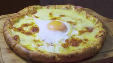 Türkçe ve Arapça geleneksel Ramazan Pide ile peynir ve yumurta üstüne. Ahşap ateş fırında pişirilir. Ahşap tahta üzerinde döndürme