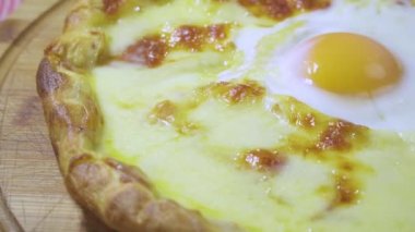 Türkçe ve Arapça geleneksel Ramazan Pide ile peynir ve yumurta üstüne. Ahşap ateş fırında pişirilir. Ahşap tahta üzerinde döndürme