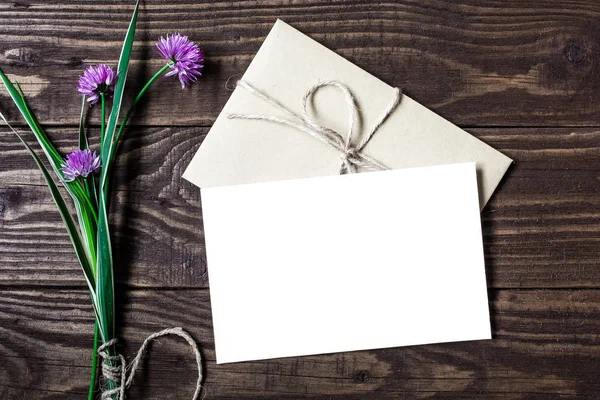 Buket mor çiçekler ve boş beyaz tebrik kartı — Stok fotoğraf