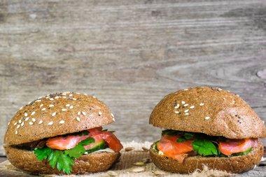 iki sandviç somon, salatalık ve otlar ile