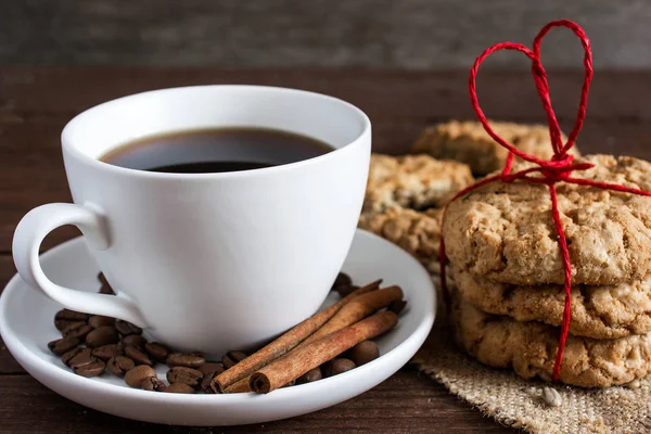 Taza de café y galletas caseras atadas con cinta roja en forma de corazón — Foto de Stock