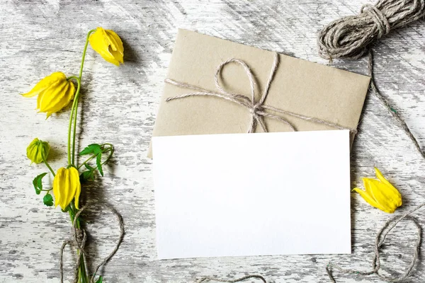 空白の白いグリーティング カードと黄色の花々 のエンベロープ — ストック写真