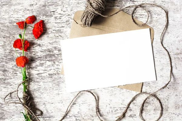 Blank vit gratulationskort med röd vallmo blommor och kuvert — Stockfoto