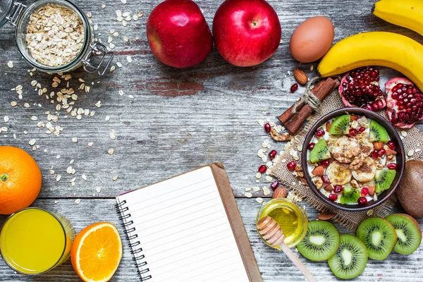 Café da manhã saudável com aveia de frutas e livro de receitas — Fotografia de Stock