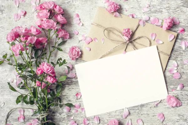 Carte de vœux blanche vierge et enveloppe avec des fleurs roses — Photo