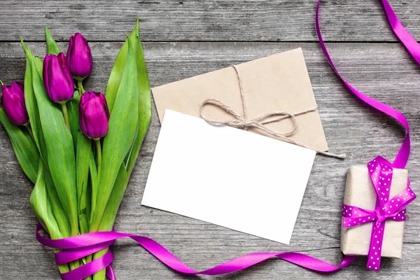 Carte de vœux blanche vierge et enveloppe avec tulipes violettes et boîte cadeau — Photo