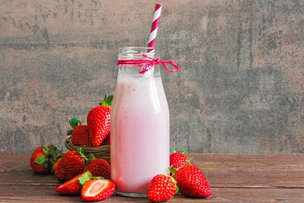 Çilek güler yüzlü veya milkshake saman ile bir şişe — Stok fotoğraf