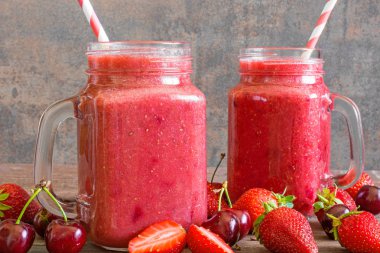 çilek ve vişne güler yüzlü bir saman ve taze meyve ile cam kavanoza