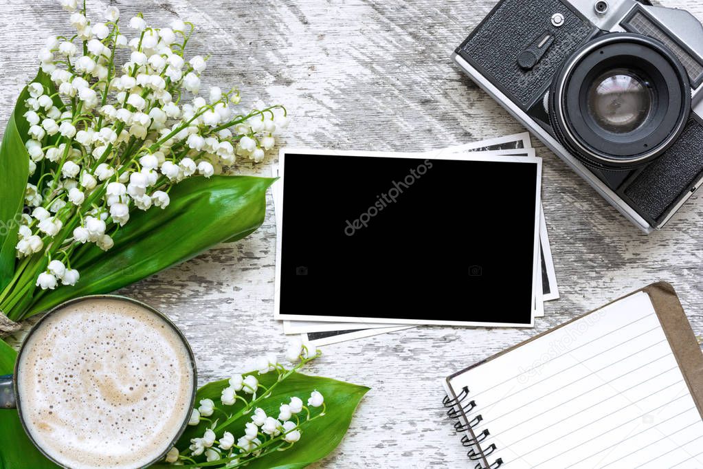 vintage retro camera with blank photo frames to put your pictures, blank notebook and coffee cup with flowers
