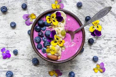 Taze meyveler, fındık, tohumlar ve yaz çiçek ile güler yüzlü kase