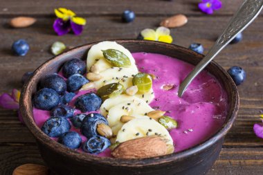 Kahvaltı berry güler yüzlü kase yaban mersini, muz, badem, kabak, ayçiçeği ve chia tohum tepesinde