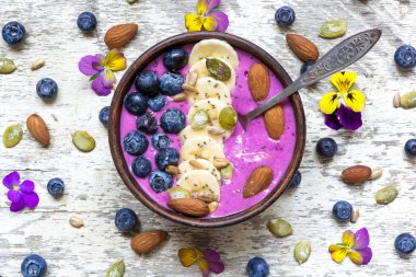 Taze meyveler, fındık, tohumlar ve kaşık ile güler yüzlü kase