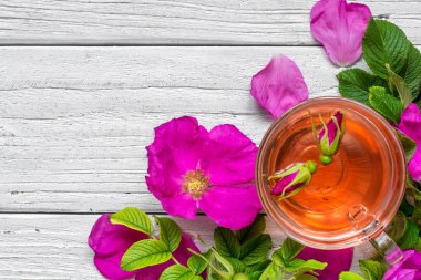 Bitkisel kuşburnu çay beyaz ahşap zemin üzerinde