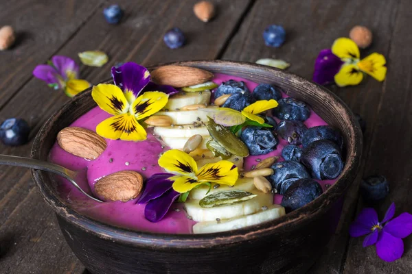Ciotola di frullato con bacche fresche, noci, semi e fiori estivi — Foto Stock