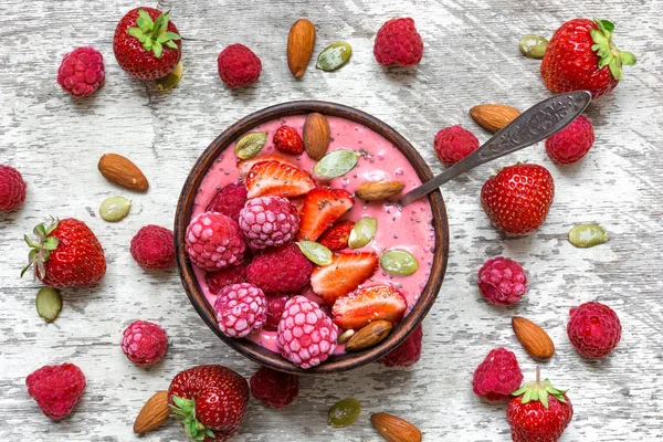 Frambuesas rosadas y batido de frutas de fresa o batido de leche en un tazón con bayas, nueces y semillas — Foto de Stock