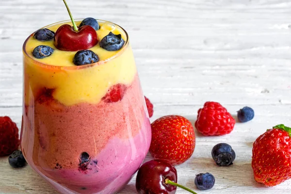 Delicioso casero en capas de frutas y bayas smoothie postre en un vaso — Foto de Stock