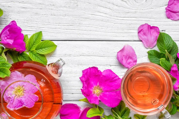 Bitkisel kuşburnu çay çaydanlık Beyaz ahşap zemin üzerinde ile