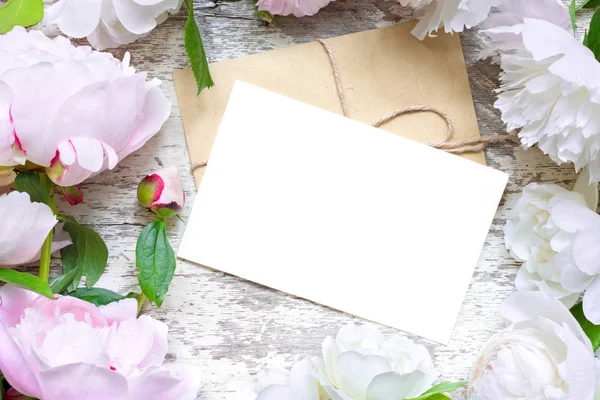 Boş tebrik kartı ve zarf çerçevesinde pembe ve beyaz peonies ve gül — Stok fotoğraf