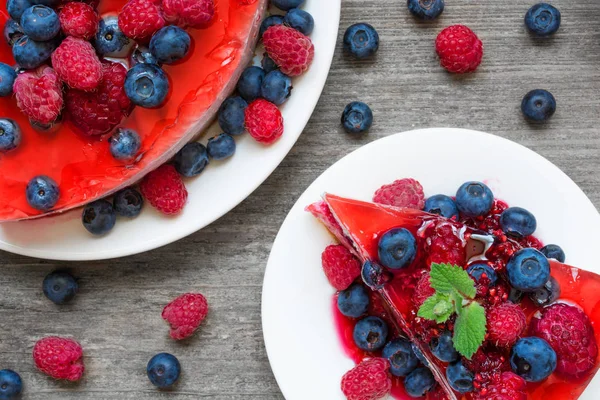 Delicioso pastel de queso y rebanada de pastel de queso con frutas de bayas y menta en un plato — Foto de Stock