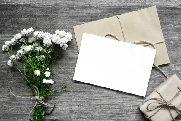 与白色鲜花花束和礼品盒信封空白白色贺卡 — 图库照片