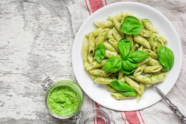 Penne pasta with basil pesto and herbs in a plate with fork — Stock Photo, Image