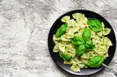 Farfalle makarna fesleğen pesto ve bir tabak içinde otlar ile