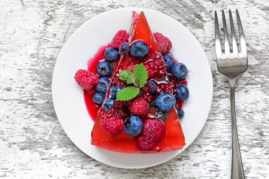 Taze meyveleri ve nane bir tabak çatal ile lezzetli peynirli kek