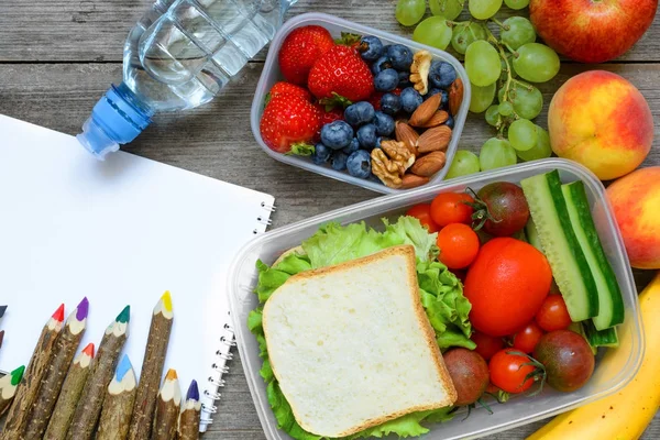 学校午餐饭盒与三明治、 水果、 蔬菜和瓶装水以彩色铅笔 — 图库照片