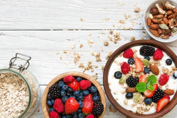 Granola caseira com iogurte grego, nozes e bagas frescas em uma tigela com cereais em ja — Fotografia de Stock