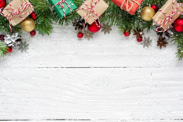 Weihnachtlicher Hintergrund mit Tannenzweigen, Dekorationen, Geschenkschachteln und Tannenzapfen — Stockfoto