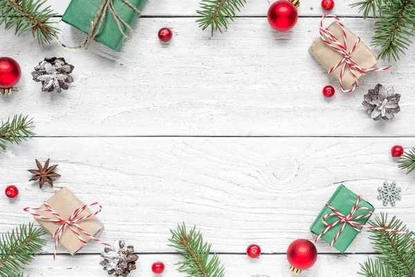 크리스마스 구성입니다. 전나무 가지, 붉은 열매, 장식, 선물 상자와 소나무 콘의 만든 프레임 — 스톡 사진