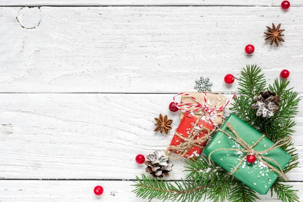 Composition de Noël en branches de sapin, baies rouges, coffrets cadeaux et cônes de pin — Photo