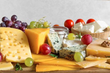 üzüm, domates ve biberiye ile rustik ahşap masa üzerinde ahşap kesme tahtası üzerinde peynir türleri