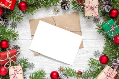 köknar ağacı dalları, kırmızı süslemeleri ve hediye kutuları Noel boş tebrik kartı çerçevesinde yapılmış