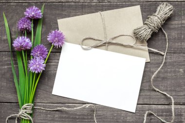 Mor kır çiçekleri buketi ve zarf bir ip ile boş beyaz tebrik kartı