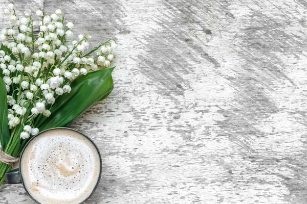 Kopje cappuccino met Lentebloemen lelietje van dalen over witte houten tafel — Stockfoto