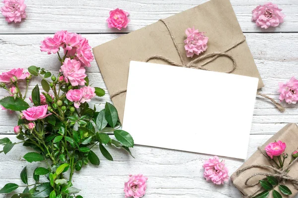 Rosa ros blommor bukett med Tom gratulationskort och presentbox — Stockfoto