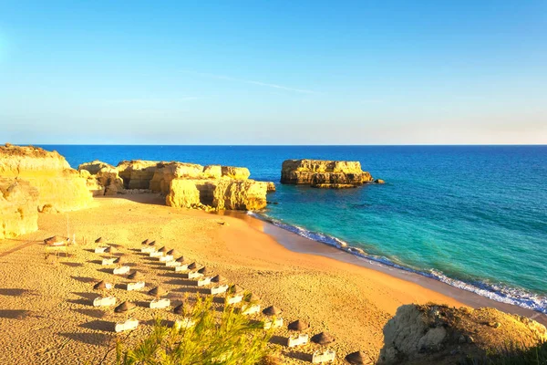 Bela praia de areia entre rochas e falésias com espreguiçadeiras perto de Albufeira, no Algarve — Fotografia de Stock