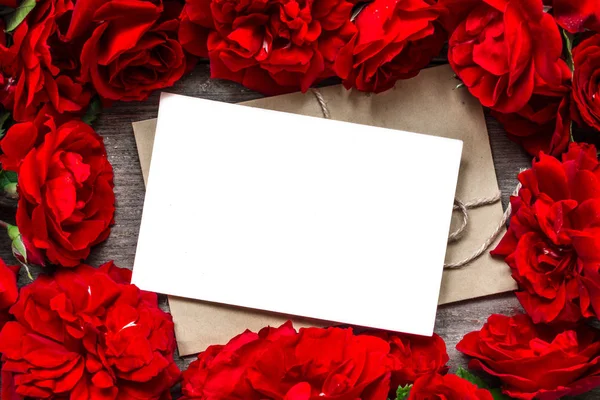 Alla hjärtans dag bakgrund. Tom gratulationskort i ram av röda rosor blommor — Stockfoto