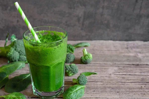 Yeşil sağlıklı güler yüzlü bir cam pipet ile brokoli, ıspanak ve chia tohum ile