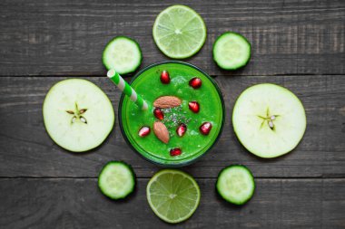 Yeşil sağlıklı güler yüzlü bir cam chia tohum, nar ve rustik ahşap masa üzerinde bir saman ile fındık. Üstten Görünüm