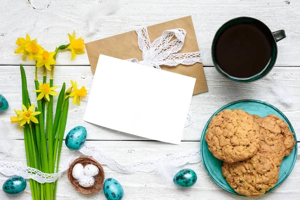 Пасхальная открытка с пасхальными яйцами, весенними цветами, чашкой кофе и печеньем на завтрак — стоковое фото