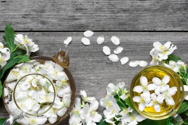 Yasemin çiçekleri ve çaydanlık ahşap arka plan üzerinde çay